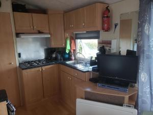 eine kleine Küche mit einem TV und einem Herd in der Unterkunft l Aire Tranquille in Hamtelle