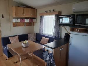 ein kleines Wohnzimmer mit einer blauen Couch und einem Tisch in der Unterkunft l Aire Tranquille in Hamtelle