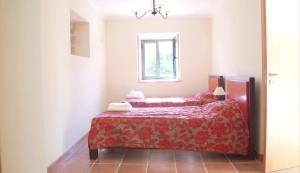 een slaapkamer met een rood bed en een raam bij Quinta de Agriboa House in Cepões