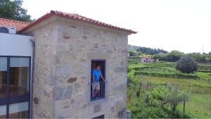 een vrouw die op een balkon van een gebouw staat bij Quinta de Agriboa House in Cepões +7 foto's
