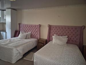 a bedroom with two beds and a large headboard at Morogoro Park Lodge  +3 photos