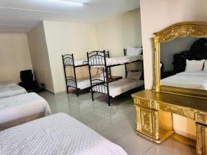 a room with two beds and a mirror and chairs at Morogoro Park Lodge 