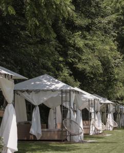 een rij tenten met stoelen in het gras bij Характер парк in Hatne +59 foto's