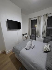 ein Schlafzimmer mit einem Bett mit einem Flachbildfernseher an der Wand in der Unterkunft Shalom Stay Tottenham in London