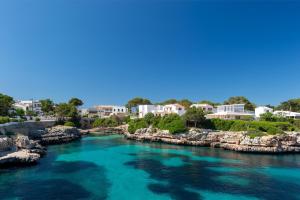une rivière avec de l'eau bleue et des bâtiments en arrière-plan dans l'établissement Chalet Addaya, à Port d'Addaia