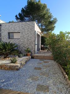 een achtertuin met een stenen loopbrug en een huis bij Studio terrasse au calme près de Narbonne in Narbonne