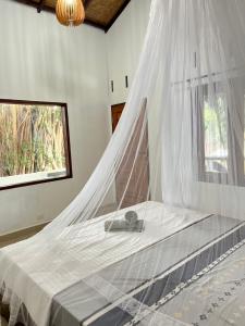 a bed with a mosquito net in a room at Thousands of Bottles - Hostel and Trekking in Bukit Lawang