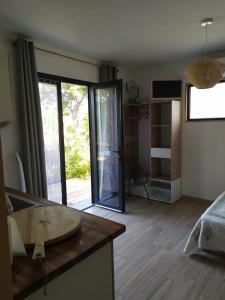 een woonkamer met een aanrecht en een groot raam bij Studio terrasse au calme près de Narbonne in Narbonne