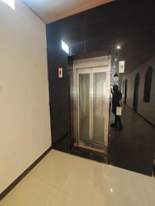 Ein Mann steht vor einer Tür in einem Gebäude. in der Unterkunft Premium Hotel Ramansh Grand - 750 Meters from Ram Mandir Ayodhya in Jāmb