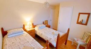 ein Schlafzimmer mit zwei Betten und einer Lampe und einem Spiegel in der Unterkunft Amazing Cottage set in Tranquil Hamlet nr Beach & Attractions - Perfect for Couples & Family's, Large Garden, Private Parking & Pets are Welcome too! in Chapel Saint Leonards