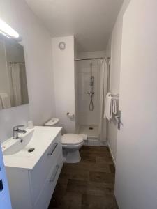 a white bathroom with a toilet and a sink at Cit'Hôtel du Parc in Carrières-sous-Poissy +20 photos