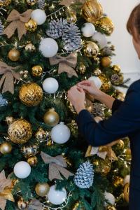 eine Frau schmückt einen Weihnachtsbaum in der Unterkunft Maison Douce Époque - Deauville in Bénerville-sur-Mer + 72 Fotos