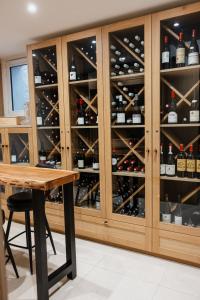 una cantina con un mobile in legno pieno di bottiglie di vino di Maison Douce Époque - Deauville a Bénerville-sur-Mer