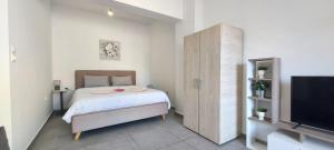ein kleines Schlafzimmer mit einem Bett und einem Fernseher in der Unterkunft Helios nest in Artemida
