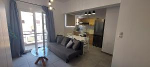 ein Wohnzimmer mit Sofa und eine Küche in der Unterkunft Helios nest in Artemida