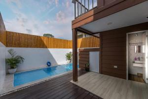 a house with a swimming pool and a wooden deck at Tagaytay Staycation with Pool and Free Private Parking in Tagaytay