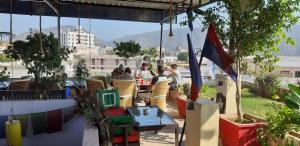 een groep mensen die aan een tafel op een terras zitten bij Pink Floyd cafe & hotel , pushkar in Pushkar
