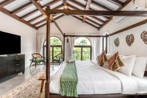 a bedroom with a large bed and a tv at ELIVAAS Signature Casa Del Mundo With Pvt Pool, Bar, Lift & Scenic Hill Vistas in Vagator