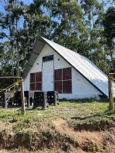 un fienile bianco con una porta bianca in un campo di Vattavada budget cottages & Aframe a Vattavada
