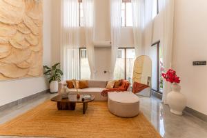 a living room with a couch and a table at ELIVAAS Signature Casa Del Mundo With Pvt Pool, Bar, Lift & Scenic Hill Vistas in Vagator