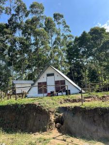 una piccola casa bianca in cima a un campo di Vattavada budget cottages & Aframe a Vattavada