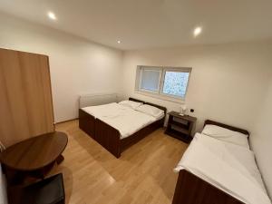 een kleine kamer met 2 bedden en een tafel bij Chata pod lesom in Drienica +3 foto's