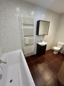 een badkamer met een bad, een toilet en een wastafel bij Chata pod lesom in Drienica