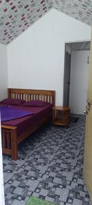 una camera da letto con un letto con lenzuola viola e una porta di Vattavada budget cottages & Aframe a Vattavada Altre 35 foto