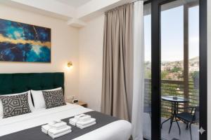 una camera d'albergo con un letto e un balcone di Brooch Boutique Hotel a Tbilisi City Altre 40 foto