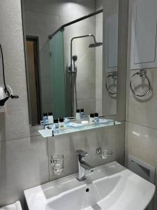 ein Badezimmer mit Waschbecken und Spiegel in der Unterkunft Chotqol sanatorium in G‘azalkent