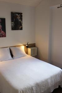 ein Schlafzimmer mit einem großen weißen Bett mit einer Lampe in der Unterkunft La petite maison in Cuxac-Cabardès