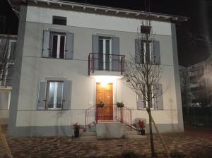 een wit huis met een rode deur 's nachts bij Hello Parma in Parma