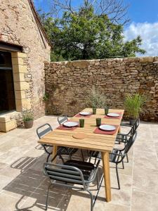 een houten tafel en stoelen op een terras bij Maison in Le Bugue