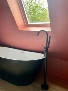 een badkuip in een kamer met een raam bij Maison in Le Bugue +11 foto's