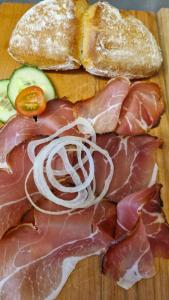 a cutting board with meat and a sandwich and bread at FEWO klein mit Garten in Feldberg