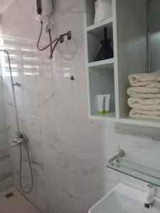 a white bathroom with a shower and a sink at Eab APARTMENT in Santeo