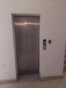 a metal elevator door in an empty room at SerenityINn in Islamabad