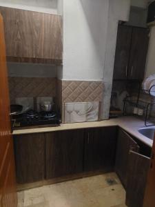 a kitchen with wooden cabinets and a stove in it at SerenityINn in Islamabad