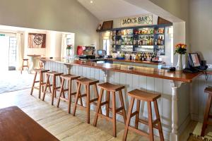 um bar com uma fila de bancos num restaurante em Soames Hotel & Jack' s Bar em Nanyuki