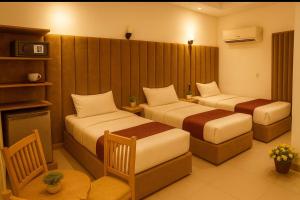 Valencia hotel Downtown في القاهرة: غرفة فندق بها سريران وطاولة