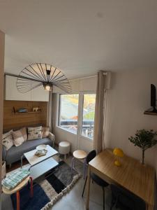 a living room with a couch and a table at Charming studio with balcony in Samoëns