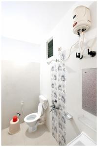 ein Badezimmer mit Toilette und Duschvorhang in der Unterkunft Chakra Tirtha Road Hotel Premium D2 Stay Near Sea Beach - WiFi # Parking And Restaurant Facilities- Budget Hotel In Puri in Puri