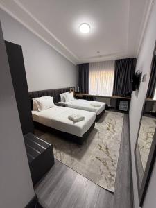 een hotelkamer met twee bedden en een raam bij Rauza Hotel Tashkent in Tasjkent