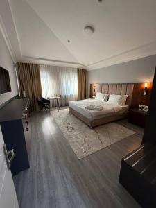 een hotelkamer met een bed en een woonkamer bij Rauza Hotel Tashkent in Tasjkent