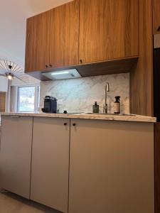 a kitchen with wooden cabinets and a counter top at Charming studio with balcony in Samoëns +7 photos