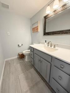a bathroom with a sink and a toilet at Lakefront 4BDBunkRm-25BA-DockFirepitSlide-14 in Sunrise Beach +78 photos