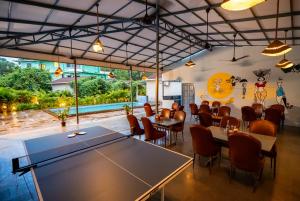 a restaurant with tables and chairs in a room at Aqua Bella Resort in Mandrem