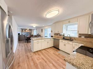 a kitchen with white cabinets and a wooden floor at Lakefront 4BDBunkRm-25BA-DockFirepitSlide-14 in Sunrise Beach