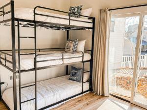 a bunk bed room with two bunk beds and a window at Lakefront 4BDBunkRm-25BA-DockFirepitSlide-14 in Sunrise Beach