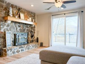 a living room with a stone fireplace and a bed at Lakefront 4BDBunkRm-25BA-DockFirepitSlide-14 in Sunrise Beach